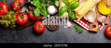 Zutaten der italienischen Küche. Gartentomaten, Nudeln, Kräuter und Gewürze. Draufsicht flach liegend Stockfoto