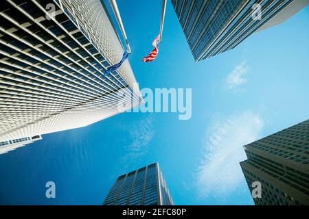 Low-Angle-Ansicht von zwei Flaggen mit Wolkenkratzern, New York City, New York State, USA Stockfoto