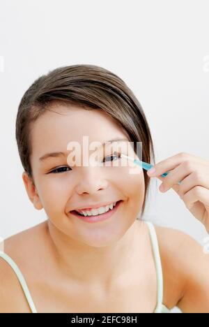 Porträt eines Teenagers, das Lidschatten auf die Augen aufführt Stockfoto