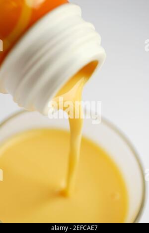 Milch aus einer Flasche in ein Glas gießen Stockfoto