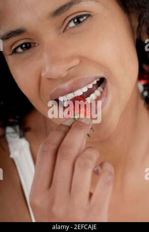 Porträt einer jungen Frau eine Erdbeere essen Stockfoto