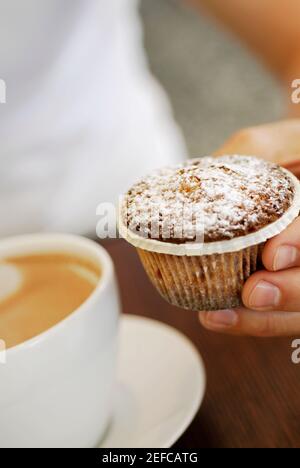 Nahaufnahme einer personÅ½s Hand mit einem Cupcake Stockfoto