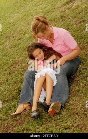 High-Angle-Ansicht einer reifen Frau und ihrer Tochter Lesen eines Buches im Park Stockfoto