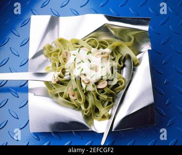 Nahaufnahme der Tagliatelle mit einer Gabel und einem Löffel auf Aluminiumfolie Stockfoto