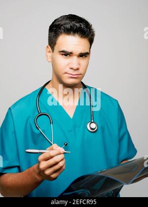 Porträt eines männlichen Chirurgen mit einem Stift und MRT Scannen Stockfoto