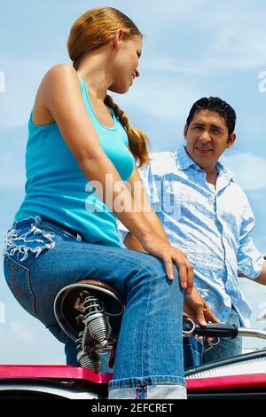 Low-Winkel-Ansicht einer jungen Frau auf einem sitzen Fahrrad neben einem mittleren Erwachsenen Mann Stockfoto