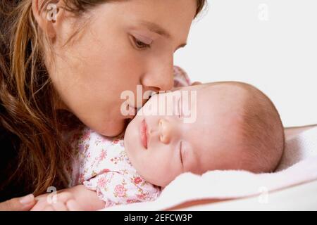 Nahaufnahme einer jungen Frau, die ihre Tochter küsst Stockfoto