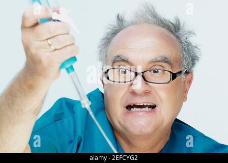 Nahaufnahme eines älteren Mannes, der einen infusionstropfen und hält Ein Gesicht machen Stockfoto