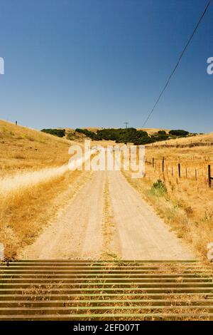 Unbefestigte Straße durch trockene Landschaft Stockfoto