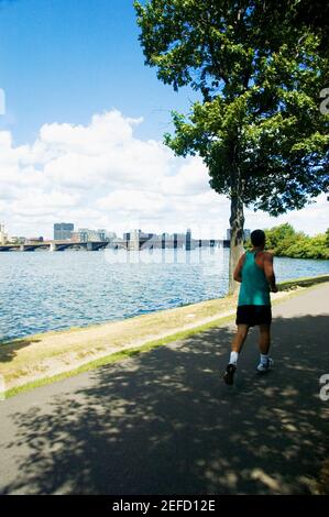 Mann beim Joggen am Ufer eines Flusses, Charles River, Longfellow Bridge, Boston, Massachusetts, USA Stockfoto