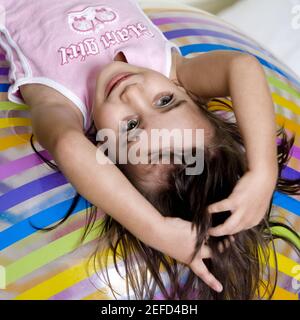 Hochwinkelansicht eines Mädchens, das auf einem Schlauchboot liegt Ball Stockfoto