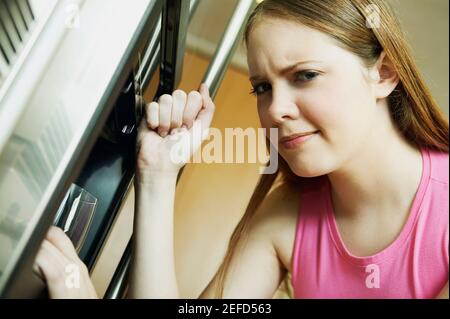 Porträt einer jungen Frau, die das Glas von einem füllt Wasserkühler Stockfoto