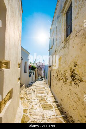 Typisch rustikale schmale gepflasterte Passage zwischen alten Steinmauern am Mittag in Lefkes, Griechenland Stockfoto