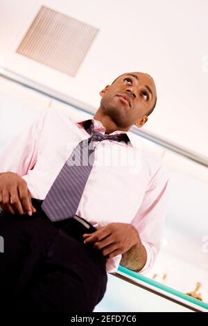 Low-Angle-Ansicht eines jungen Mannes, der sich an einem lehnt Barcounter Stockfoto