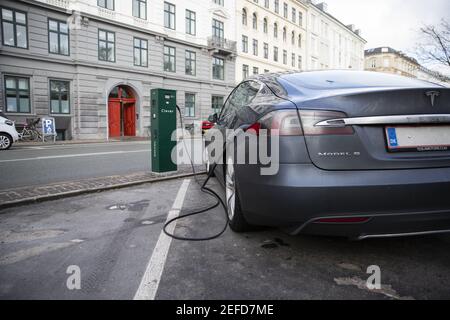 Ein Tesla-Elektroauto wird geparkt und aufgeladen. Tesla eines der größten Elektrofahrzeuge und Unternehmen für saubere Energie. Stockfoto