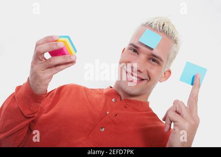 Porträt eines jungen Mannes lächelnd mit Haftnotizen Stockfoto