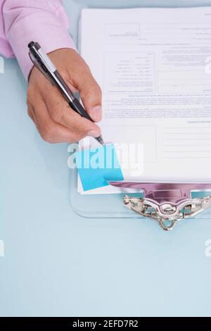 Hochwinkelansicht einer personŽs-Handschrift auf einem Dokument Stockfoto