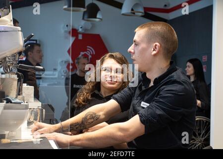 MINSK, WEISSRUSSLAND - Januar 2021: Invalidität Inklusion Team in einem inklusiven Café. Ein einzigartiges Projekt, ein inklusives Café. Ein Ort, an dem alle Mitarbeiter behindert sind. Wird von einer Person mit Down-Syndrom verwaltet. Alle Baristas sind deaktiviert. Stockfoto