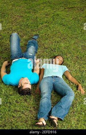 Erhöhte Ansicht eines jungen Paares liegen auf dem Rasen Stockfoto