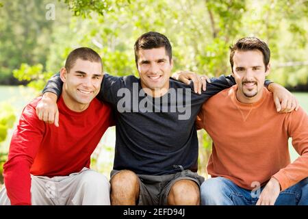 Porträt von drei Freunden sitzen und lächeln Stockfoto
