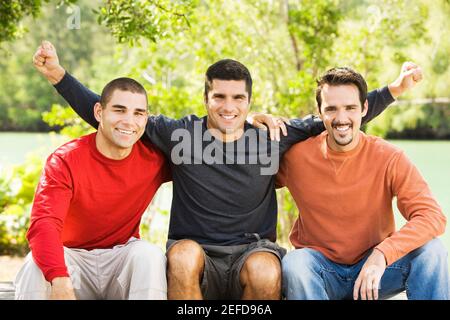 Porträt von drei Freunden sitzen und lächeln Stockfoto