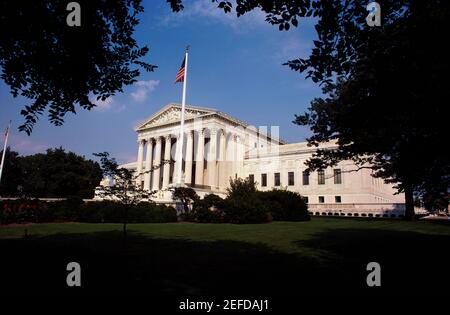 Niedrige Ansicht einer amerikanischen Flagge vor einem Regierungsgebäude, US Supreme Court, Washington DC, USA Stockfoto