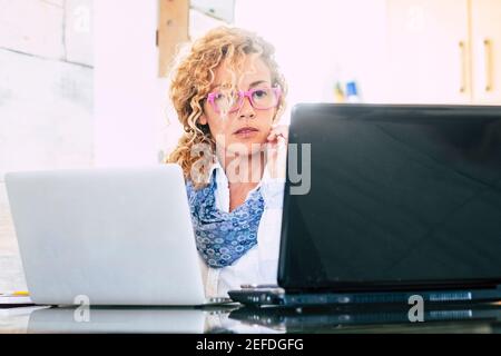 Home Office Arbeit Frau kaukasischen Menschen mit zwei Laptop-Computer - Geschäftsfrau und intelligente Arbeitstätigkeit Lebensstil Menschen - Erwachsene Sehen Sie sich PC-Display A an Stockfoto