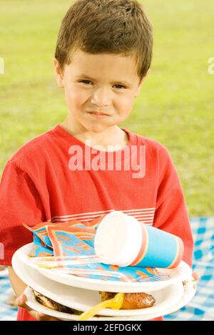 Porträt eines Jungen, der Teller hält Stockfoto