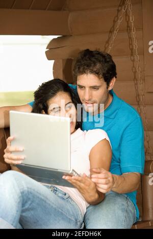 Nahaufnahme eines Mannes mit mittlerem Erwachsenen und einer jungen Frau Sitzen auf der Veranda Stockfoto