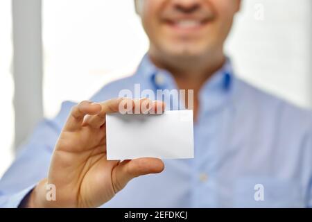 Nahaufnahme eines lächelnden Mannes mit Visitenkarte Stockfoto