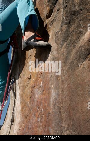 Low-Section-Ansicht einer Kletterin, die einen Felsen erklimmen Gesicht Stockfoto