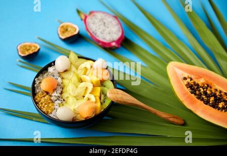 Mischen Sie exotische Früchte in einer Schüssel mit einem Holzlöffel Stockfoto