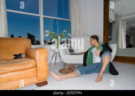 Junger Mann an einem Notebook arbeitet Stockfoto