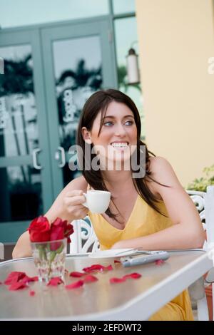 Teenager-Mädchen hält eine Tasse Tee und lächelt Stockfoto