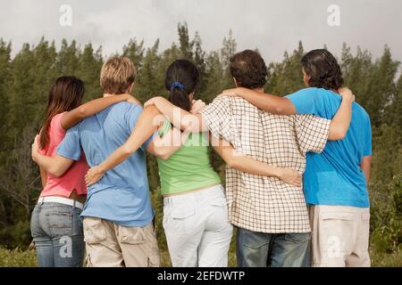 Rückansicht von fünf Freunden mit ihren Armen um jeden herum Andere Stockfoto