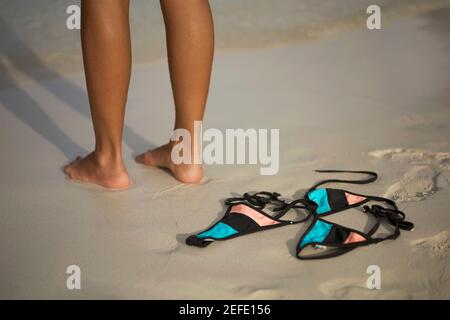 Niedrige Ansicht einer Frau, die am Strand steht In der Nähe eines Bikinis Stockfoto