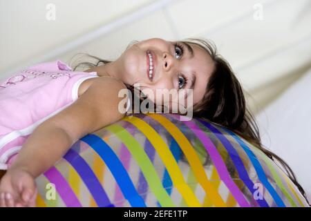 Seitenprofil eines Mädchens, das auf einem aufblasbaren Ball liegt Stockfoto