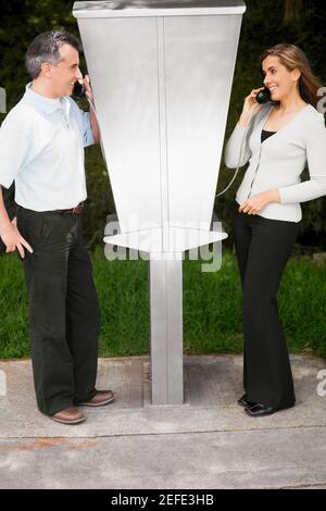 Seitenprofil eines mittelerwachsenen Paares, das über Bezahlung spricht Telefone Stockfoto