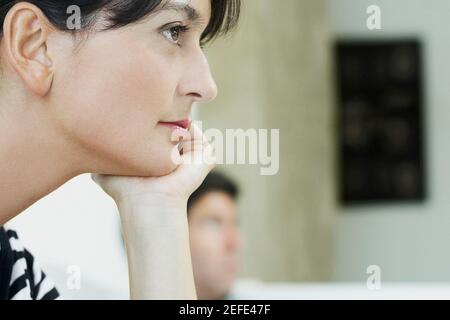 Nahaufnahme einer mittleren erwachsenen Frau mit einem mittleren Erwachsenen Mann im Hintergrund Stockfoto