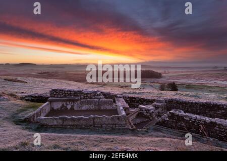 Ein herrlicher Sonnenaufgang am römischen Fort von Housesteads mit den Überresten eines Wassertanks und Latrinen, die im Bild hervorstehen - Hadrianmauer, Northumberland Stockfoto