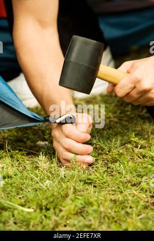 Nahaufnahme einer personÅ½s Hand, die ein Zelt aufstellt Stockfoto