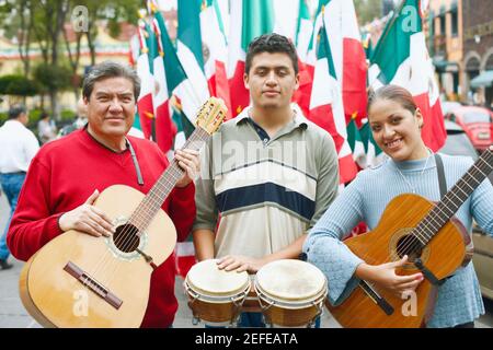 Portrait von drei Musikern, die mit ihren Musikinstrumenten stehen Stockfoto