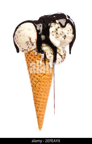 Eis: Eiskegel mit Stracciatella und viel Schokoladensauce isoliert auf weißem Hintergrund Stockfoto