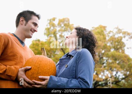 Low-Angle-Ansicht eines Paares, das sich einen Kürbis teilt Stockfoto