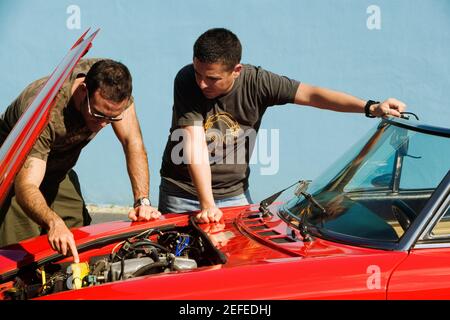 Zwei Männer mittleren Erwachsenen, die einen Automotor untersuchen, Miami, Florida, USA Stockfoto