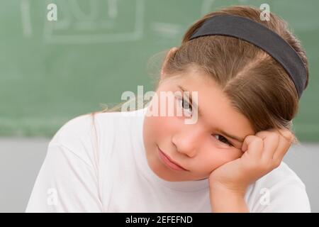 Porträt eines Schulmädchens, das in einem Klassenzimmer denkt Stockfoto