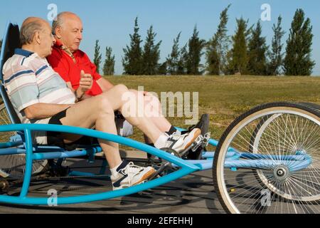 Zwei ältere Männer auf einem Vierrad Stockfoto