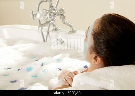 Nahaufnahme einer jungen Frau, die eine Gesichtsmaske trägt Eine Badewanne Stockfoto