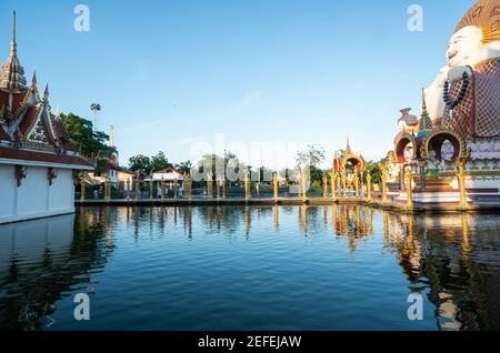 KOH SAMUI, THAILAND - 10. Januar 2020: Frau in einem roten Kleid steht auf einer Brücke zu einer riesigen bunten buddha-Statue am Wat Plai laem Tempel auf koh Stockfoto