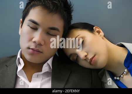 Geschäftsmann und eine Geschäftsfrau, die auf einem Flughafen schläft Stockfoto